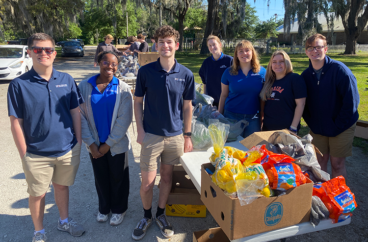 pls members with fls at a day of service event to package up food
